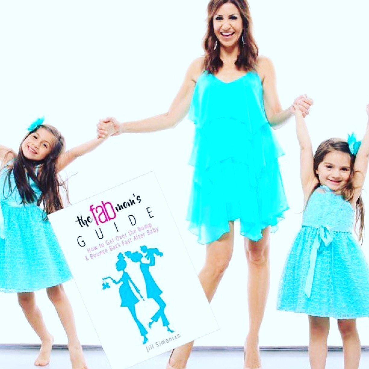 Jill Simonian, author of The FAB Mom's Guide book, holds hands with her daughters.