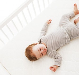 Baby laying on Newton crib mattress