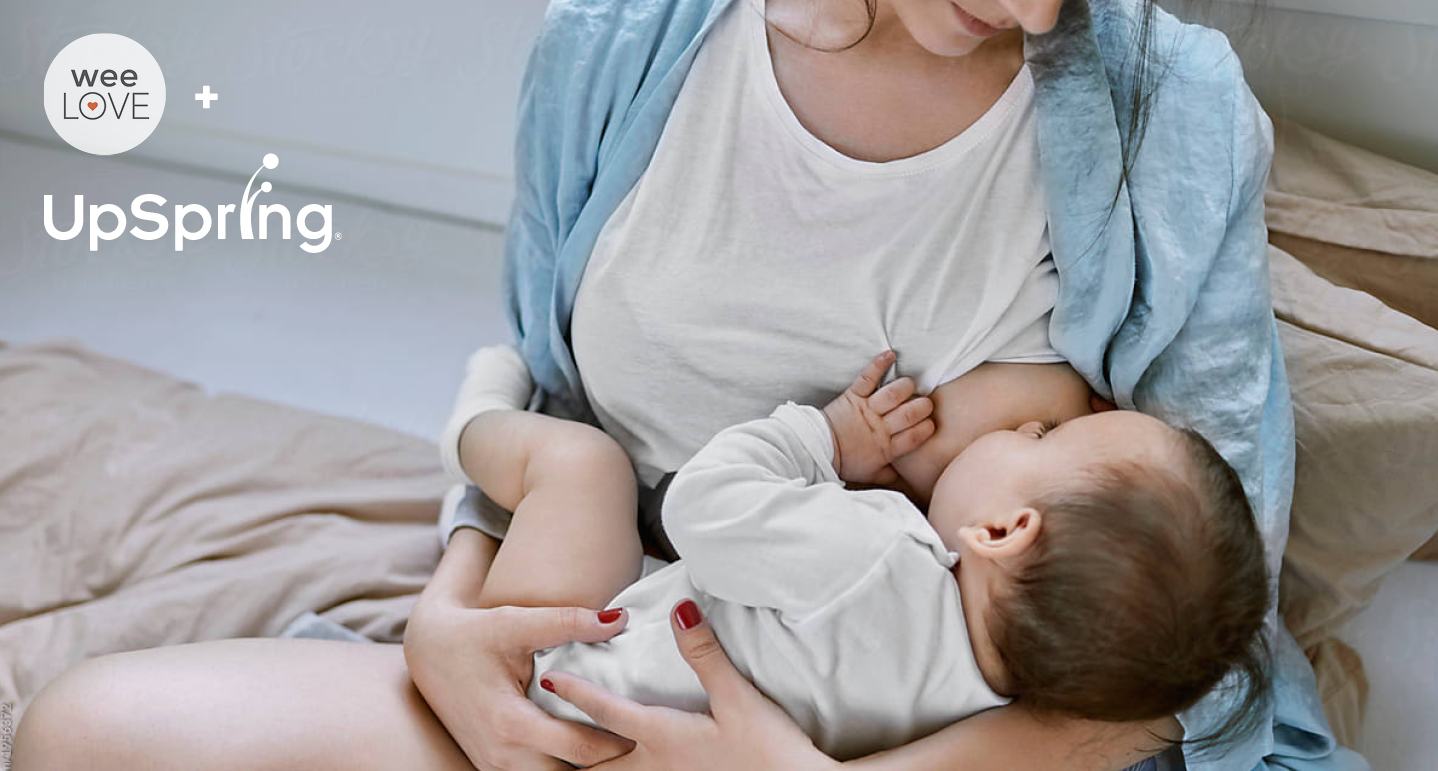 a close up picture of a woman sitting in her bed, breastfeeding her baby.